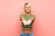 © luismolinero - Young blonde woman over isolated pink background holding copyspace imaginary on the palm to insert an ad