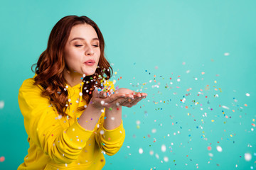 Wall Mural - Photo of curly wavy trendy white cheerful charming sweet pretty youngster blowing confetti away from his hands palms enjoying pocess isolated over turquoise vibrant color background