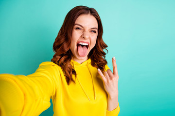 Poster - Photo of white curly wavy rude grimacing girl loving listening to heavy metal music taking selfie photographing her madness isolated over teal vivid color background