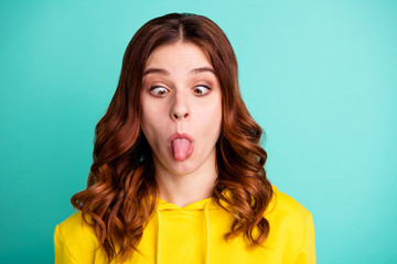 Wall Mural - Close up photo of wavy foolish funky funny charming girlish youngster showing her tongue staring at stick out isolated over teal vibrant color background