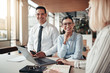 © Flamingo Images - Smiling young businesswoman working with colleagues in an office