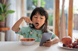 © Odua Images - distracted kid using mobile phone while having breakfast on the table
