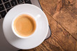 © Ivan - Cup of coffee on a laptop keyboard. Work place modern. Laptop (notebook) with cup of coffee and notepad with pen on old wooden table.