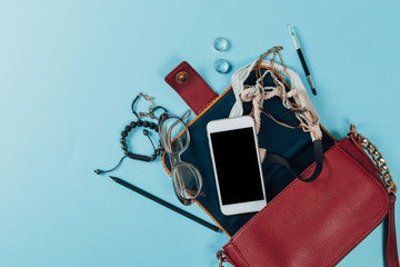 Wall Mural - Contents of woman's bag.Top view of Women bag and lady stuff with copyspace on pink background