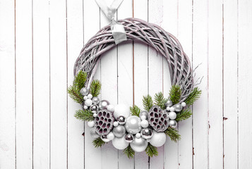 Christmas wreath on wood background with silver ornaments and christmas tree branches