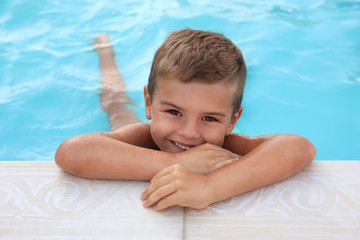 Wall Mural - Cute little boy in outdoor swimming pool