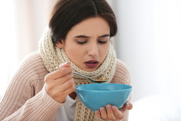 Wall Mural - Sick young woman eating soup to cure flu