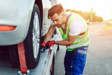 Handsome middle age man working in towing service on the road. Roadside assistance concept.