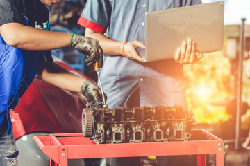 Mechanic with a tool in his hands repairing the motor of the machine.