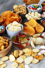 Wall Mural - Salty snacks. Pretzels, chips, crackers and candy sweets on table