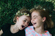 © Ali Lanenga/Stocksy - Close up of laughing siblings laying on grass
