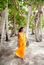 Beautiful Young Woman Walking Among Palm Trees In Tahiti