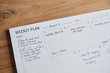 © Trinette Reed/Stocksy - Overhead shot of a weekly planner on a wooden desk
