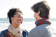 © Trinette Reed/Stocksy - Mixed race couple smiling at each other at the beach