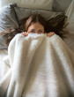 © Carolyn Lagattuta/Stocksy - Teen girl hiding under the covers