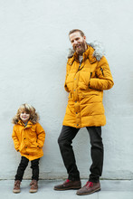Father And Kid Wearing Yellow Hooded Coat.