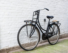 Traditional Old Bicycle Leaning On White Brick Wall