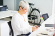© guille Faingold/Stocksy - Cheerful mature businesswoman using phone