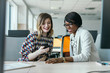© Lumina/Stocksy - Young Businesswomen Working Together and Using Cell Phone