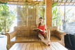 © Alexey Karamonov/Tetra Images - Woman wearing swimsuit reading book on wooden sofa