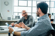 © FS Productions/Tetra Images - Men using digital tablet during meeting in office