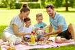 © Syda Productions - family, leisure and people concept - happy mother, father and two little sons having picnic at summer park
