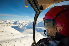 Helicopter Pilot Looking Out At Winter Landscape While Flying