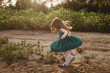 © Cavan Images - Little girl twirling her dress in backlight and field of flowers