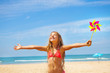 Girl with pinwheel on the beach happy and smiling