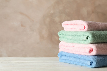 Wall Mural - Stack of clean towels against brown background, space for text