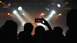 © Cavan Images - Silhouette of a crowd of people at a concert venue watching the stage