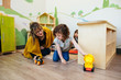 © Cavan Images - Teacher and student interact while playing with toy cars