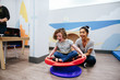 © Cavan Images - Teacher smiles while she spins her student on a sensory seat