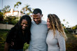 © Cavan Images - Family smiling and hugging on beach at sunset