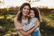 © Cavan Images - Portrait of young mother and daughter in sunny field