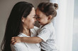 © Cavan Images - Side view of young mother and toddler boy looking at each other
