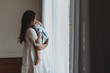 © Cavan Images - Young pregnant mother cuddling with young son in natural light studio