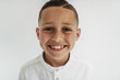 © Cavan Images - Portrait of young school-aged boy smiling in studio