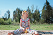 © Cavan Images - Portrait of a young girl sat outside eating with a flower in her hair