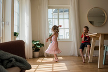 Young Girl Dancing And Playing At Home With Her Brother