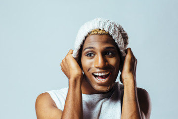 Wall Mural - Portrait of a young man with knit cap in studio having fun