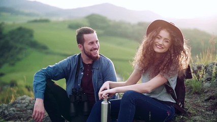Wall Mural - young tourist couple travellers with hiking in nature, resting. slow motion.
