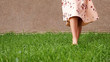 © lenblr - bare feet of slim lady in long pink summer dress walk along lush green grass lawn on warm day close low angle shot copy space