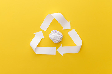 Wall Mural - top view of white triangle with crumpled paper on yellow background