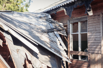 Old ruined house after long standing with collapsed walls and windows.