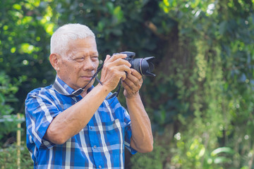 Senior man using a camera to take photo