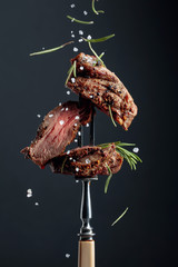 Wall Mural - Grilled ribeye beef steak with rosemary on a black background.