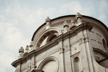 White marble cathedral with statues and patterns on the facade of a building in the center of Brescia, Lombardy, Italy. Traditional Italian architecture with old Roman elements, arches and columns.