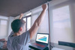 © GENETTICA - Business success concpet. Young man celebrating an achievement with arms raised in front of laptop with financial graph that contains an arrow going up on the screen. All screen graphics are made up.