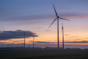 Wall Mural - windmills on a field in Germany during a beautiful multicolored sunrise